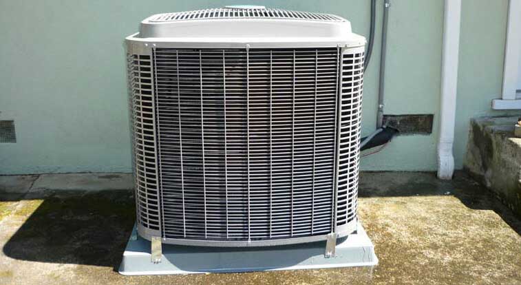 Air conditioning unit installed on outdoor concrete surface, providing cooling solution.